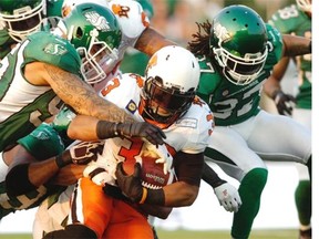 Saskatchewan Roughriders defensive end Ricky Foley (#95) and teammates take tackle BC Lions running back Andrew Harris (#33) during a CFL game held at Mosaic Stadium in Regina, Sask. on Saturday July 12, 2014.