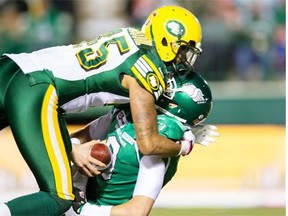 Seth Doege #9 of the Saskatchewan Roughriders is sacked by Dexter McCoil #45 of the Edmonton Eskimos in a game between the Edmonton Eskimos and Saskatchewan Roughriders in week 20 of the 2014 CFL season at Mosaic Stadium on November 08, 2014 in Regina.