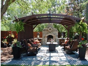 A shaded sitting area with an imposing stone fireplace in the backyard of Edith Marshall, winner in the category of Decorative Back Garden in the 2014 Edmonton Horticultural Society competition