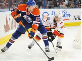 Leon Draisaitl of the Edmonton Oilers moves past Calgary's Kris Russell during pre-season action at Rexall Place on Sept. 21, 2014. The Oilers won 3-1.
