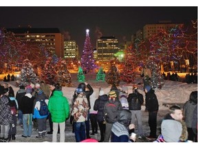 A small crowd watches as the Alberta Legislature grounds in Edmonton are lit up with over 300 trees adorned with more than 127,000 LEDs during the official Christmas lighting on December 6, 2012.