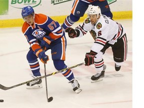 Oilers' David Perron and Blackhawks' Adam Clendening fight for the puck during second period action at the Chicago Blackhawks and Edmonton Oilers preseason game at the Credit Union Centre in Saskatoon on Sunday.