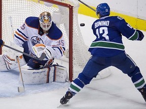 Vancouver Canucks centre Nick Bonino (13) tries to get a shot past Edmonton Oilers goaltender Viktor Fasth (35) during the second period of NHL action in Vancouver on Oct. 11, 2014.
