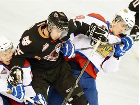 Calgary Hitmen Greg Chase (middle) is checked by Edmonton Oil Kings Edgars Kulda (left) and Martin Gernat (right) during first period WHL action in Game 7 of the Eastern Conference Final in Edmonton on April 30, 2013.