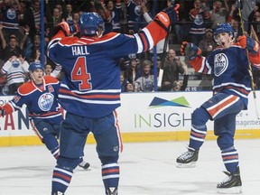 Ryan Nugent-Hopkins #93, Taylor Hall #4 and Jordan Eberle #14 of the Edmonton Oilers celebrate after scoring a goal in a game against the Tampa Bay Lightning on Oct. 20, 2014, at Rexall Place in Edmonton.