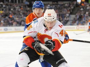 Edmonton Oilers forward Vladimir Tkachev follows Calgary Flames David Wolf in pre-season NHL action at Rexall Place in Edmonton on Sunday, Sept. 21, 2014.