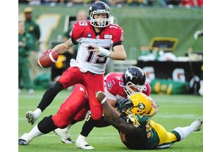 Stampeders quarterback Bo Levi Mitchell evades this tackle by an unidentified Eskimos defenceman during their CFL game at Commonwealth Stadium in Edmonton on Thursday, July 24, 2014.