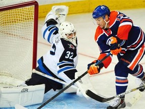 Steven Pinizzotto (13)  gets a good shot on goalie Danny Taylor (32) in the Edmonton Oilers pre-season game against the Winnipeg Jets at Rexall Place on Sept. 29, 2014.
