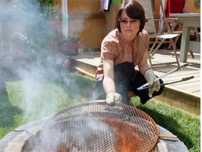 Susan Copeland of Bylaw Community Relations shows how damp grass adds to the smoke of a backyard firepit in this 2008 photo.