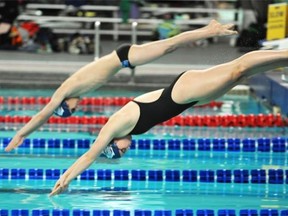 Swimmers arc into the pool at the Kinsmen Centre. A city report calls for widening the centre’s “functionally obsolete” 50-metre warm-up pool to 10 lanes from six.