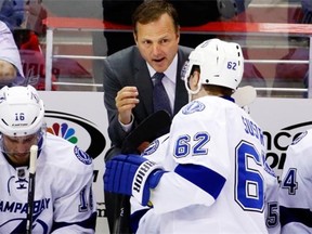 Tampa Bay Lightning head coach Jon Cooper, top, talks with defenseman Andrej Sustr during a timeout in NHL action against the Washington Capitals on April 13, 2014, in Washington.