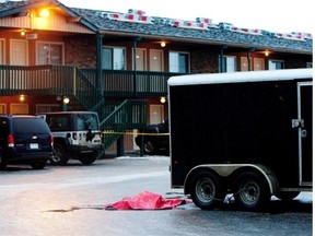 A tarp covers the spot where Darren Johnston was found with life-threatening injuries in the parking lot of the Lodge Motor Inn on Dec. 29, 2011, in Edmonton. Edmonton Journal/File