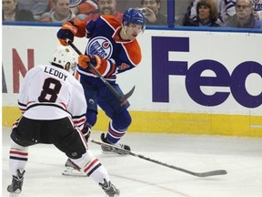 Taylor Hall of the Edmonton Oilers fires the puck past Nick Leddy of the Chicago Blackhawks during second-period National Hockey League action at Rexall Place on Nov. 25, 2013.
