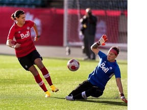 Team Canada’s Christine Sinclair tries to get the ball past goal keeper Erin McLeod during team practice at Commonwealth Stadium on October 23, 2014.
