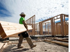 In this Nov. 16, 2012 photo, a construction worker carries lumber as he works on a house frame for a new home in Chula Vista, Calif. Confidence among U.S. homebuilders inched up in Novemeber to the highest level in more than six and a half years, as builders reported the best market for newly built homes since the housing boom.(AP Photo/Gregory Bull)