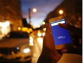 In this photo illustration, a woman uses the Uber app on an Samsung smartphone in Berlin, Germany. Uber operates in 42 countries over 200 cities worldwide. David MacLean, vice-president of the Alberta Enterprise Group, says ridesharing services are the future of the taxi industry so Edmonton should get on board.