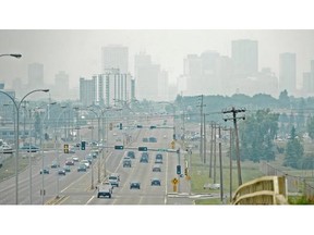 Traffic on Baseline Road heads toward the hazy city skyline, caused by smoke and ash from forest fires on July 16, 2014.