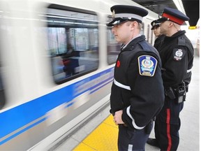 Transit Peace Officers Andrew Martin, left, on the LRT platform with EPS Cst. Joseph Elias and Halley Barrantes walking the LRT beat for the LRT Transit and Police Partnership program in Edmonton on Thursday, Nov. 6, 2014.