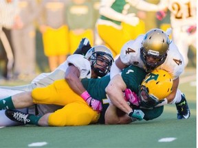 University of Alberta Golden Bears running back Ed Ilnicki protects the ball as he’s tackled by Jayden McKoy, left, and Jonathan Jones of the Manitoba Bisonís during a Canada West football game at Foote Field on Oct. 4, 2014.