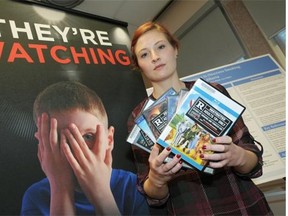 University of Alberta student Kelly West holds some movie DVDs she says should be rated R due to smoking and tobacco imagery. She says her research has revealed over one third of youth smoking in Alberta can be attributed to the portrayal of smoking imagery on youth-rated films.