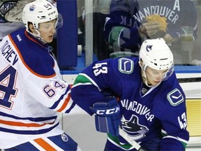Vancouver Canucks prospect Curtis Valk battles Vladimir Tkachev of the Edmonton Oilers for a loose puck during the second period at the Youngstars Tournament against Edmonton Oilers in Penticton, B.C., on Friday, September 12, 2014.