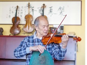 Violin maker and repairman PJ Tan tests a violin at PJ Tan Violin Shop in southeast Edmonton on Aug. 27, 2014. Tan is one of the few remaining violin makers left in Canada.