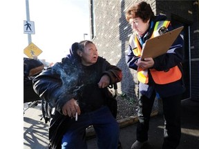 Volunteer Dorian Smith asks questions of Gloria Bone, 56, for this year’s Homeless Count in front of the Bissell Centre in Edmonton on Thursday, Oct. 16, 2014.