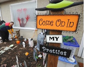Wayne Brown puts the finishing touches on his yard, designed along with his wife Sharon, at 8622 95 Ave. in Edmonton on Oct. 29, 2014. He calls it “Cartoon Alley” for its emphasis on cartoon characters that aren’t too scary for younger kids.