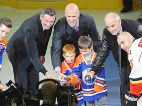 Wayne Gretzky, left, Mark Messier and Lee Fogolin,  Members of the 1984 Edmonton Oilers, help Stollery kids Grayson and Cohen with the ceremonial puck drop before the Oilers season-opener against the Calgary Flames on Thursday.