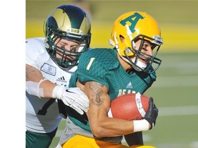 Wide Receiver Tylor Henry of the University of Alberta Golden Bears tries to get away Saturday from John Kiesman of the University of Regina Rams at Foote Field in Edmonton.