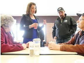 Wildrose Party Leader Danielle Smith, second from left, speaks with, from left, Kelsie Kaval and Ian Donovan in Coaldale, Alta., Friday, March 30, 2012.