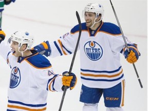 Will Acton, left, and Mark Arcobello of the Edmonton Oilers celebrate Acton’s goal against the Vancouver Canucks during a National Hockey League pre-season game at Vancouver on Saturday.