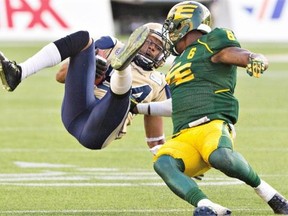 Winnipeg Blue Bombers Romby Bryant (84) is hit by Edmonton Eskimos Alonzo Lawrence (6) during second half action in Edmonton on Monday, Oct. 13, 2014.