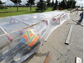 Men work under plastic sheeting to keep potential rain off of the fresh cement as a crew puts new sidewalks along 82nd Street north of 137th Avenue in Edmonton in 2012.