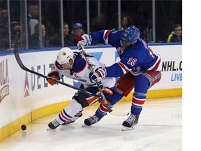Marc Staal of the New York Rangers hits Jordan Eberle of the Edmonton Oilers along the boards during the first period at Madison Square Garden on Nov. 9, 2014 in New York City.