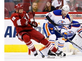 Arizona Coyotes’ David Moss (18) creates interference in front of the goal as the puck gets blocked by Edmonton Oilers’ Ben Scrivens, right, as Oilers’ Brad Hunt (59) defends during the first period of an NHL hockey game Tuesday, Dec. 16, 2014, in Glendale, Ariz.