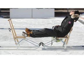 Call it snowtanning: Edwin Hendrawan catches some rays while manning the kick sleds during Winter Walk Day at City Hall on a very cold day in Edmonton on Wednesday, February 5, 2014.