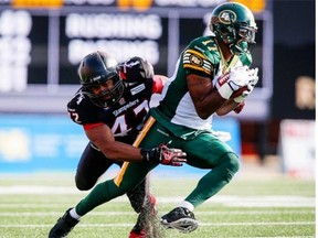 Edmonton Eskimos wide receiver Shamawd Chambers tries to get away from Maalik Bomar of the Calgary Stampeders during a Canadian Football League game at McMahon Stadiumin Calgary on Sept. 1, 2014.