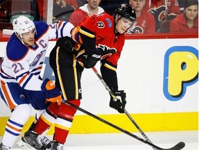 Edmonton Oilers’ Andrew Ference, left, tangles with Calgary Flames’ Joe Colborne during first period NHL hockey action in Calgary, Wednesday, Dec. 31, 2014.