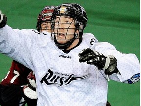Edmonton Rush forward Mark Matthews (front) eludes a check by Colorado Mammoth defenceman Dan Coates during National Lacrosse League game action in Edmonton on April 5, 2014.