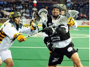 The Edmonton Rush’s Zack Greer gets tied up by the Minnesota Swam’s David Earl (l) and Jason Noble in National Lacrosse League action Jan. 10, 2015, at Edmonton’s Rexall Place.