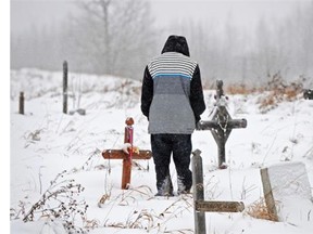A father at the gravesite of his infant daughter in the Paul Band First Nation. She died while in government care.