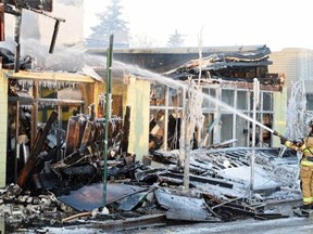 Firefighters put out hotspots during an early morning fire in the historic Roxy Theatre on on Tuesday Jan. 13, 2015.