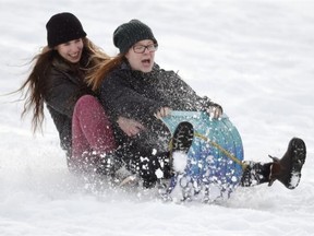 St. Joseph High school teachers Robyn MacKay (front) and Carey Van der Zalm zip down Connors Hill on a wood sled made in Shop Class in Edmonton on Jan. 16, 2015. The City of Edmonton has closed all toboggan hills because they are too icy.