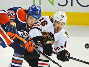 Leon Draisaitl of the Edmonton Oilers and Marcus Kruger of the Chicago Black Hawks battle for the puck during a National Hockey League game at Rexall Place on Nov. 23, 2014.