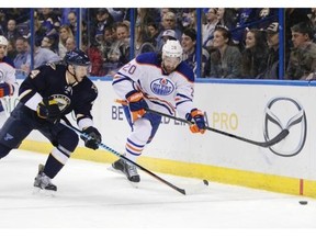 St. Louis Blues’ Carl Gunnarsson (4) races Edmonton Oilers’ Luke Gazdic (20) to the lose puck in the first period of a NHL hockey game, Tuesday, Jan. 13, 2015 in St. Louis.