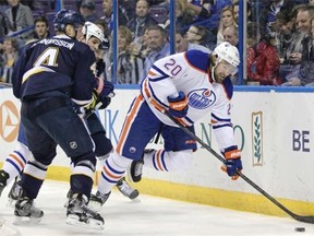 Luke Gazdic of the Edmonton Oilers beats St. Louis Blues defenceman Carl Gunnarsson to a loose puck during Tuesday’s National Hockey League game at the Scottrade Center in St. Louis.