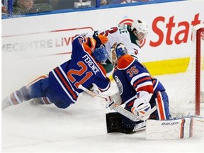 Minnesota Wild’s Charlie Coyle scores from behind the net on Edmonton Oilers goalie Viktor Fasth as defenceman Andrew Ference tries to check in during Tuesday’s National Hockey League game at Rexall Place.