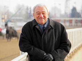 Mitch Klimove leans on a railing at the Northlands racetrack. Klimove, now in his 90s, has owned hundreds of horses over more than six decades.