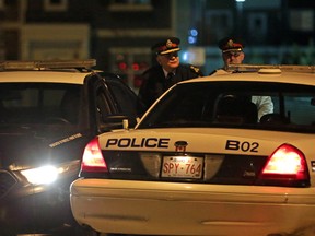Edmonton police Chief Rod Knecht (left) surveys the scene where seven bodies were discovered inside a house in Edmonton December 30, 2014.